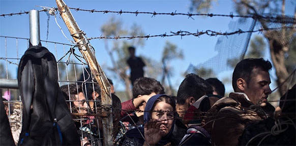 Flüchtlinge hinter einem Zaun