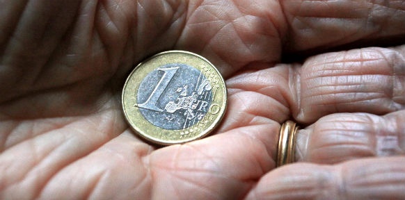 In einer Hand liegt eine Ein-Euromünze
