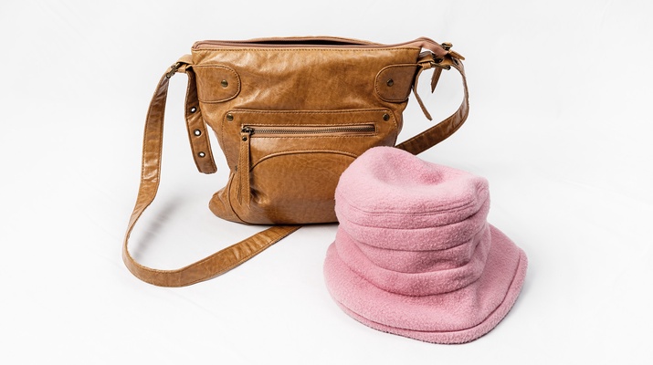Eine braune Handtasche und ein rosa Hut