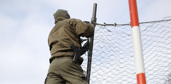 Soldat beim Montieren eines Grenzzauns