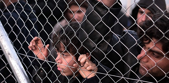 Flüchtlinge hinter einem Zaun