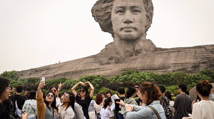 Touristengruppe vor riesiger Mao-Statue