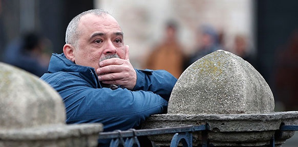 AP/LEFTERIS PITARAKIS Mann in Istanbul lehnt an Betonzaun