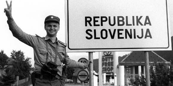 Polizist neben dem Schild mit der Aufschrift "Republik Slowenien"