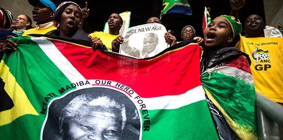Trauernde Afrikaner mit Bildern von Nelson Mandela