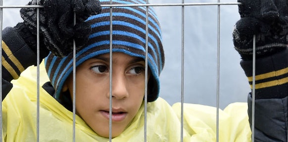 APA/HELMUT FOHRINGER Ein Flüchtlingskind hinter einem Zaun