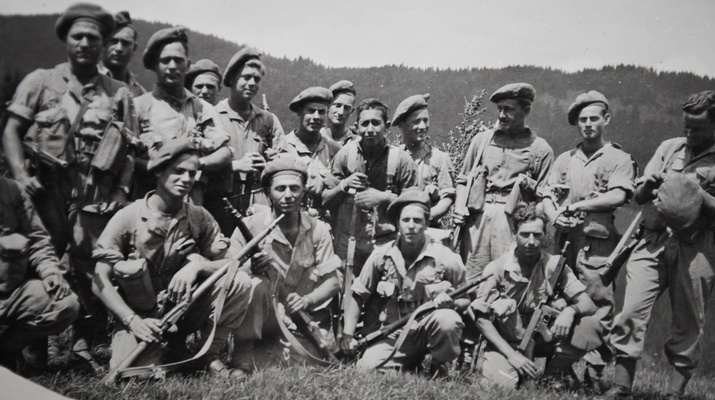 Altes Schwarz-Weiß-Foto: eine Gruppe junger, uniformierter Männer mit Waffen