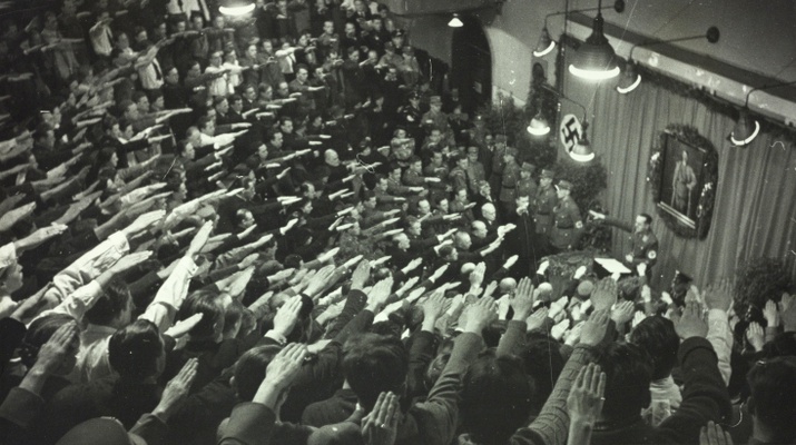 Altes SW-Foto aus dem Jahr 1938. Im Hörsaal hängen Hakenkreuze, die Studenten heben ihre Hände zum Hitlergruß