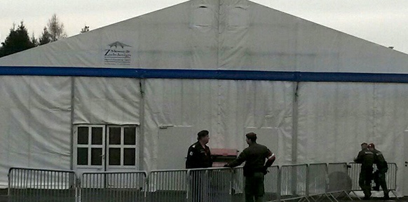 Zelthalle, davor Polizisten