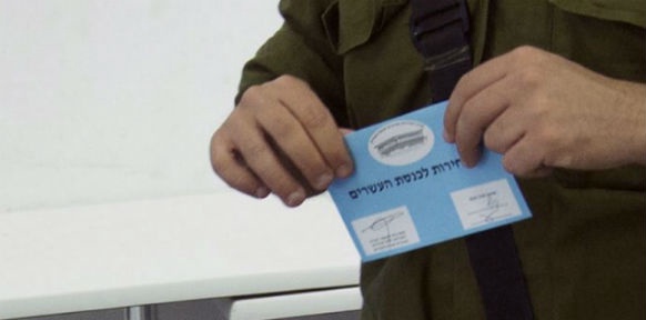 Ein israelsicher Soldat mit seiner Wahlkarte