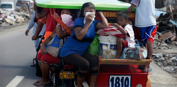 Menschen auf einem Motorradtaxi in Tacloban