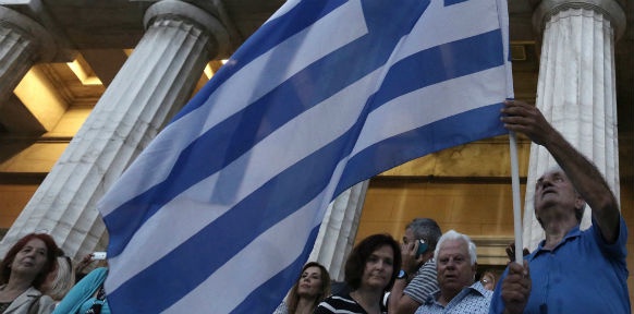 Menschen schwenken die Griechische Fahne