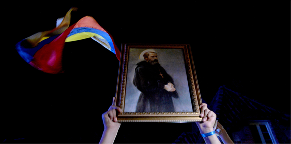 APA/AFP/DIANA SANCHEZ Frau mit kolumbianische Flagge und Heiligenbild