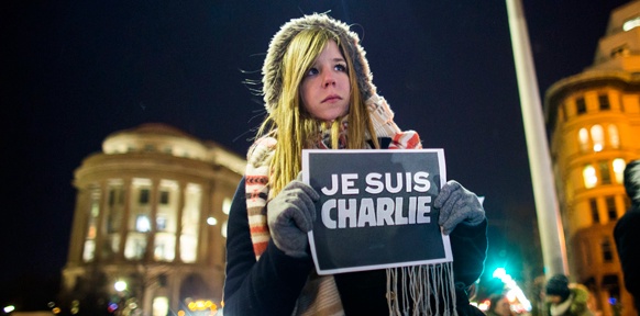 Demonstrantin mit einem Schild "Je Suis Charlie"