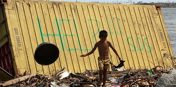 Chaos nach dem Taifun, kleiner Junge vor Help-Schrift