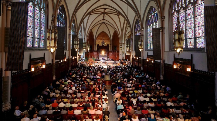 In einer gut gefüllten Kirche wird gerade eine Messe abgehalten.