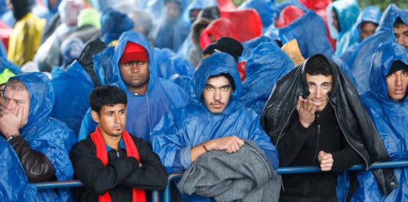 Syrische Flüchtlinge mit Regenumhängen
