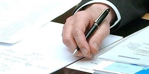 Hand auf Unterlagen mit Kugelschreiber