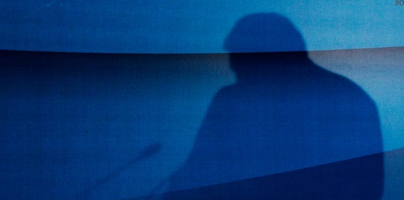 Schatten eines Mannes auf einem blauen Tuch