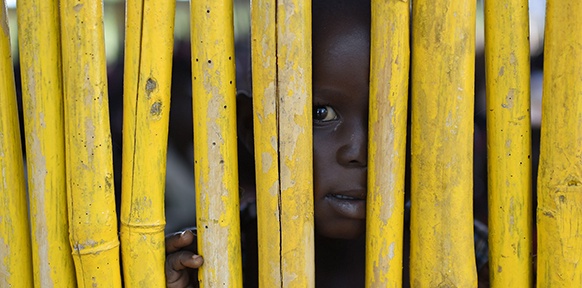 Ein Kind hinter einem Zaun