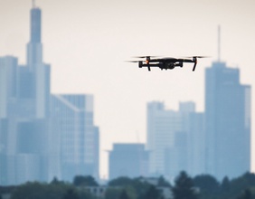 Eine Drohne fliegt über einer Stadt.