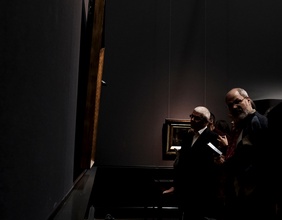 Menschen in einem dunklen Museumsraum