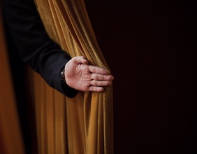 Hand öffnet einen Vorhang