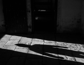 Schatten eins Mannes auf Kopfsteinpflaster