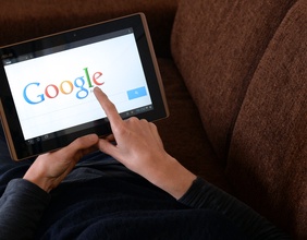 Eine Frau benutzt auf ihrem iPad die Suchmaschiene Google.