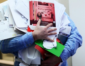 Mann trägt Altpapier