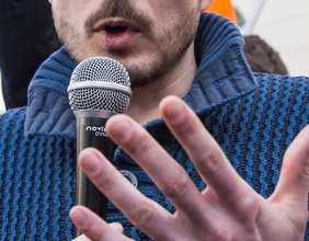 Mann spricht mit Mikrofon in der Hand