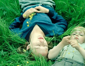 Szene aus dem Film: Astrid liegt mit ihrem Sohn Lasse im Gras.