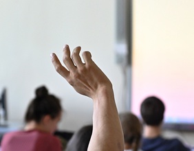 Eine Hand zeigt auf im Klassenzimmer