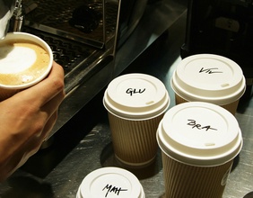 Kaffee wird in Becher gegossen, Deckel beschriftet