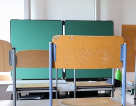 Klassenzimmer: Hochgestellte Stühle und Tafel