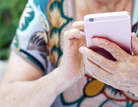 Ältere Dame hält ein Smartphone in Händen