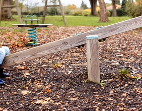 Kind auf einer Wippe, Spielplatz