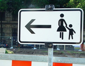 Schild mit Pfeil, Frau und Kind