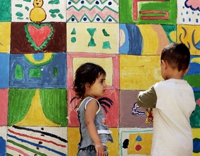 Kinder vor bunt bemalter Wand