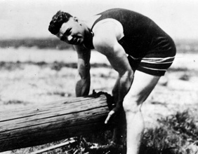 Boxer Jack Dempsey beim Training für die.Weltmeisterschaft: Heben eines.Baumstamms, um 1920