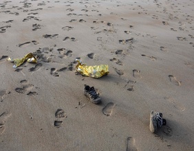 Schuhe und Spuren im Sand