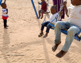 Flüchtlingskinder aus dem Sudan auf Schaukeln