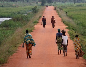 Menschen gehen auf einer Landstraße in Burundi