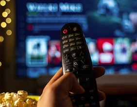 Popcorn, Fernbedienung und Netflix im Hintergrund