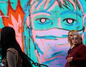 Frauen in Mexiko vor einem Grafitti