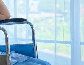 Dame in einem Rollstuhl in einem Krankenhaus am Fenster