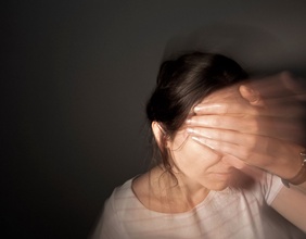 Frau hält sich Stirn