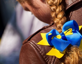 Junges Mädchen mit Zopf und Masche in den Farben der Ukraine