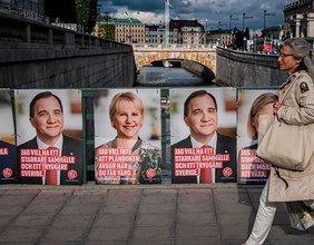 Eine Frau geht in Stockholm an Wahlplakaten vorbei