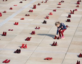 Eine Installation von blutroten Schuhen, die als Mahnmal für Gewalt gegen Frauen dienen sollen